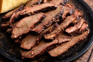 Sliced smoked beef brisket on rustic plate