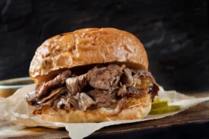 Roast beef sandwich on bun with pickles